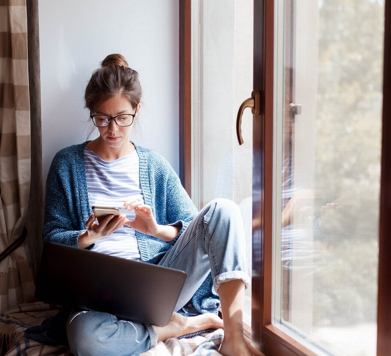 Woman with smartphone and laptop