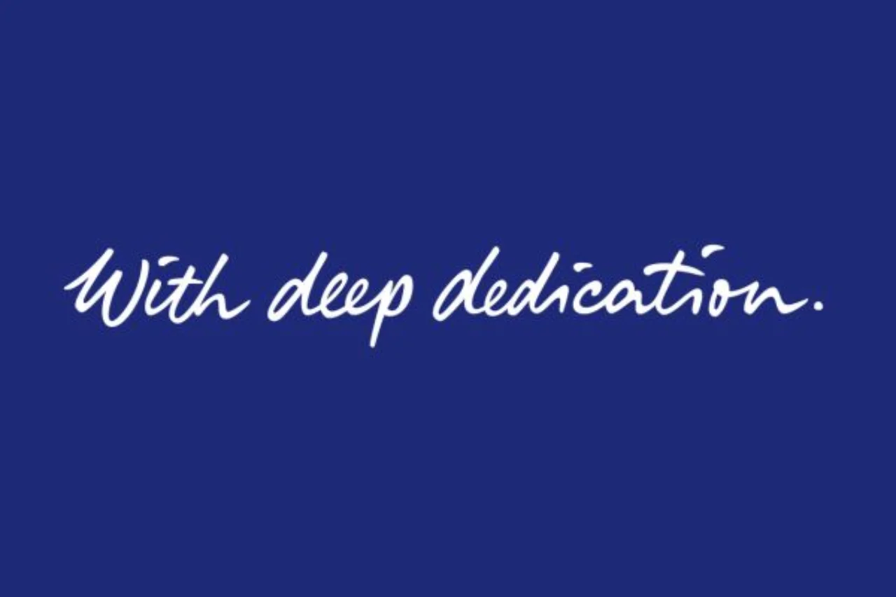 Der Claim „With deep dedication“ auf einem tiefblauen Hintergrund.