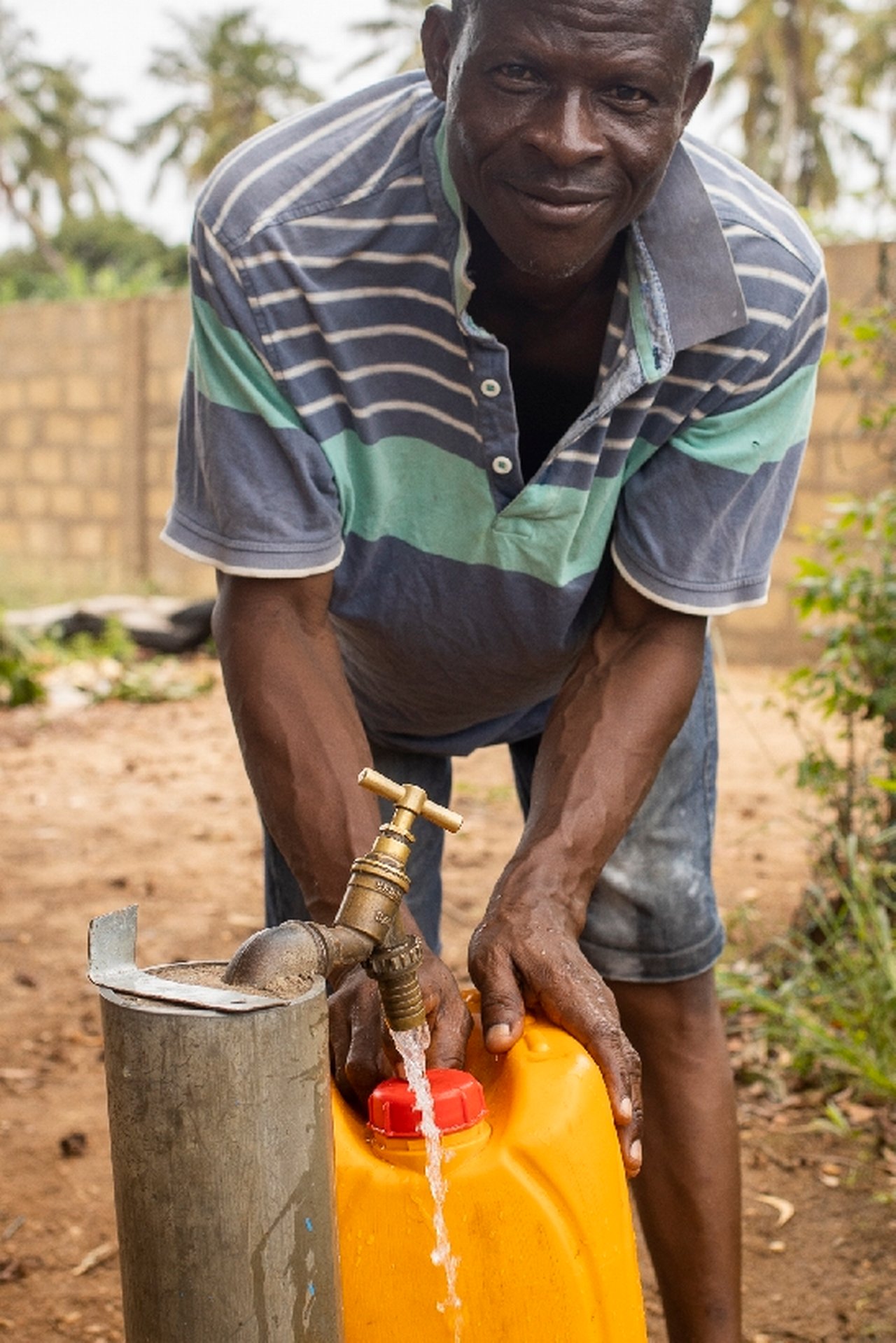 A resident draws drinking water from a public well of the Ghana Water Company