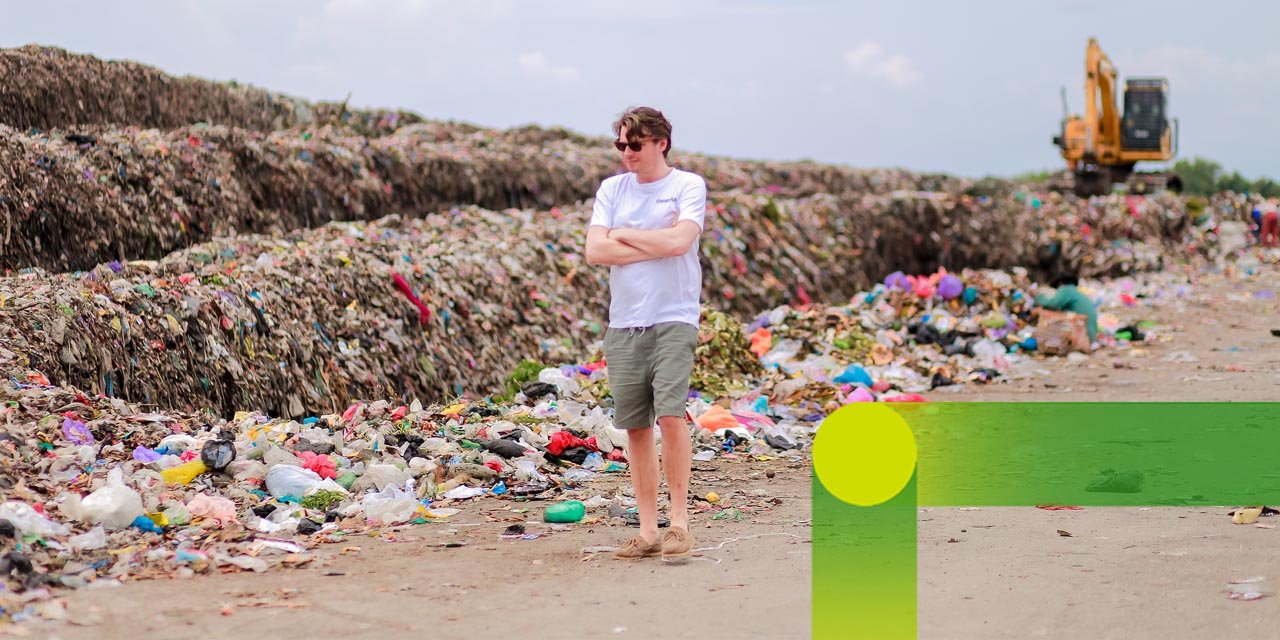 Cleanhub: man walking along mountains of waste on the beach