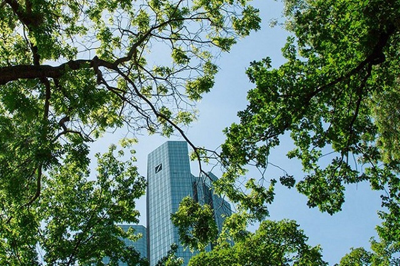 Deutsche Bank Headquarters viewed through lush green tree branches
