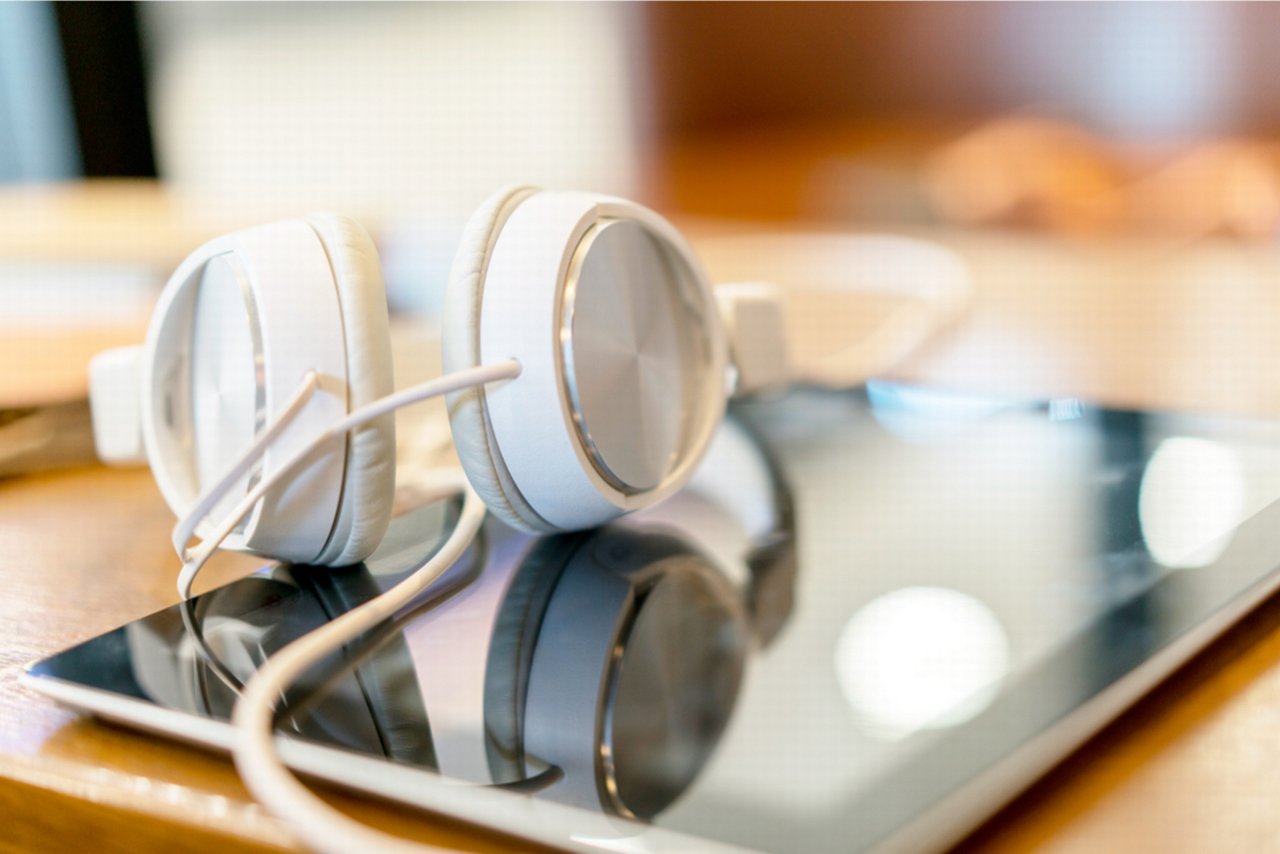 The picture shows the tablet and headphones lying on the table.