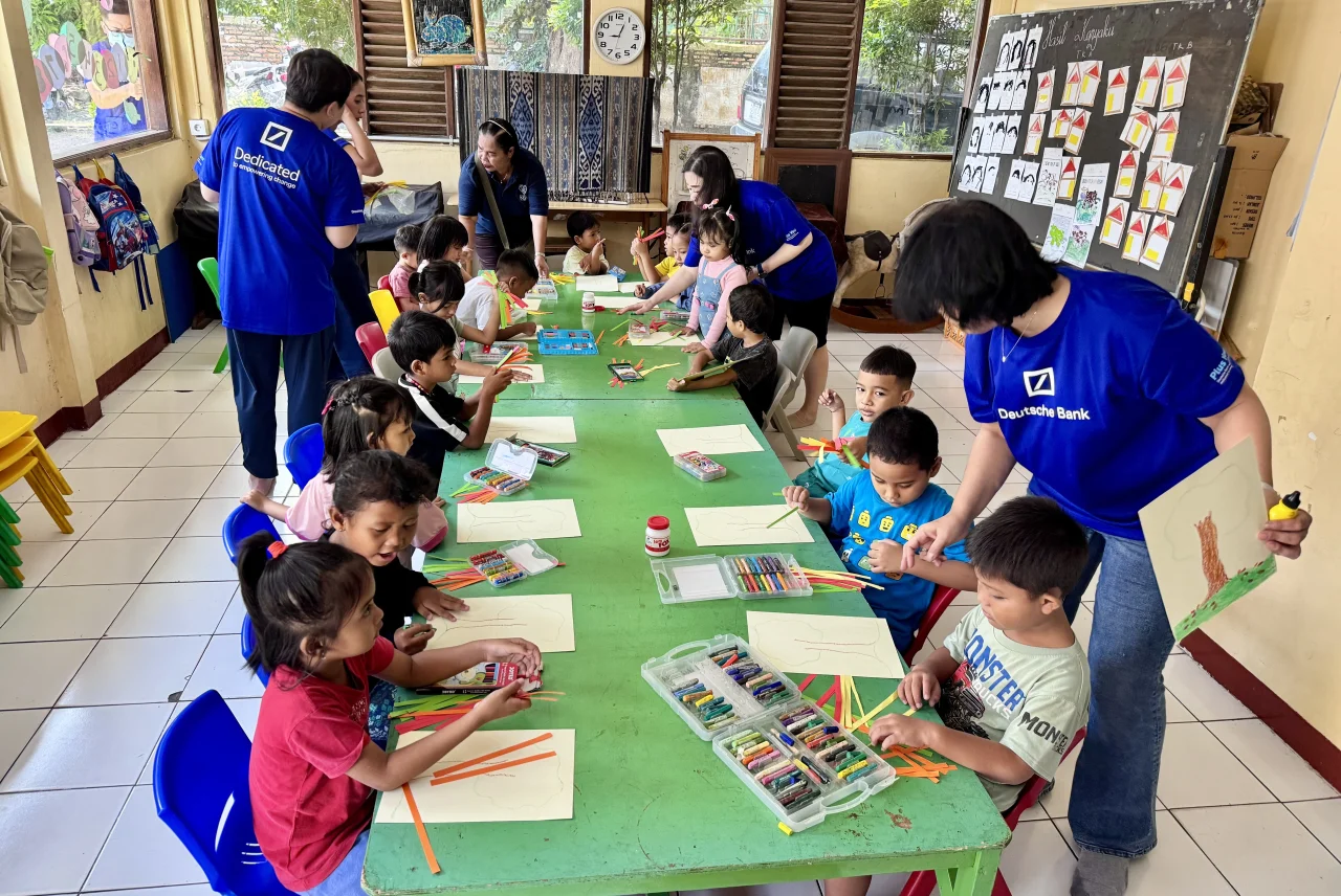 Children taking part in a creative activity with volunteers