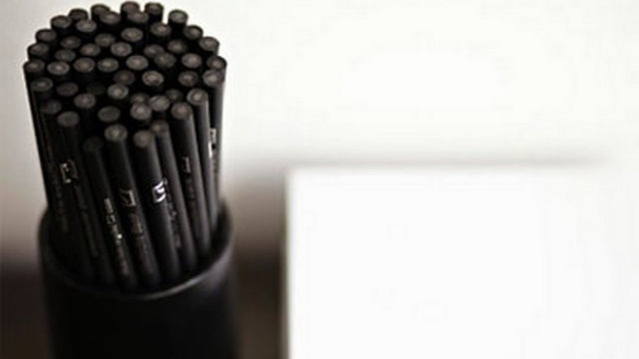 A bundle of black pencils made from recycled plastic, standing upright in a pencil holder