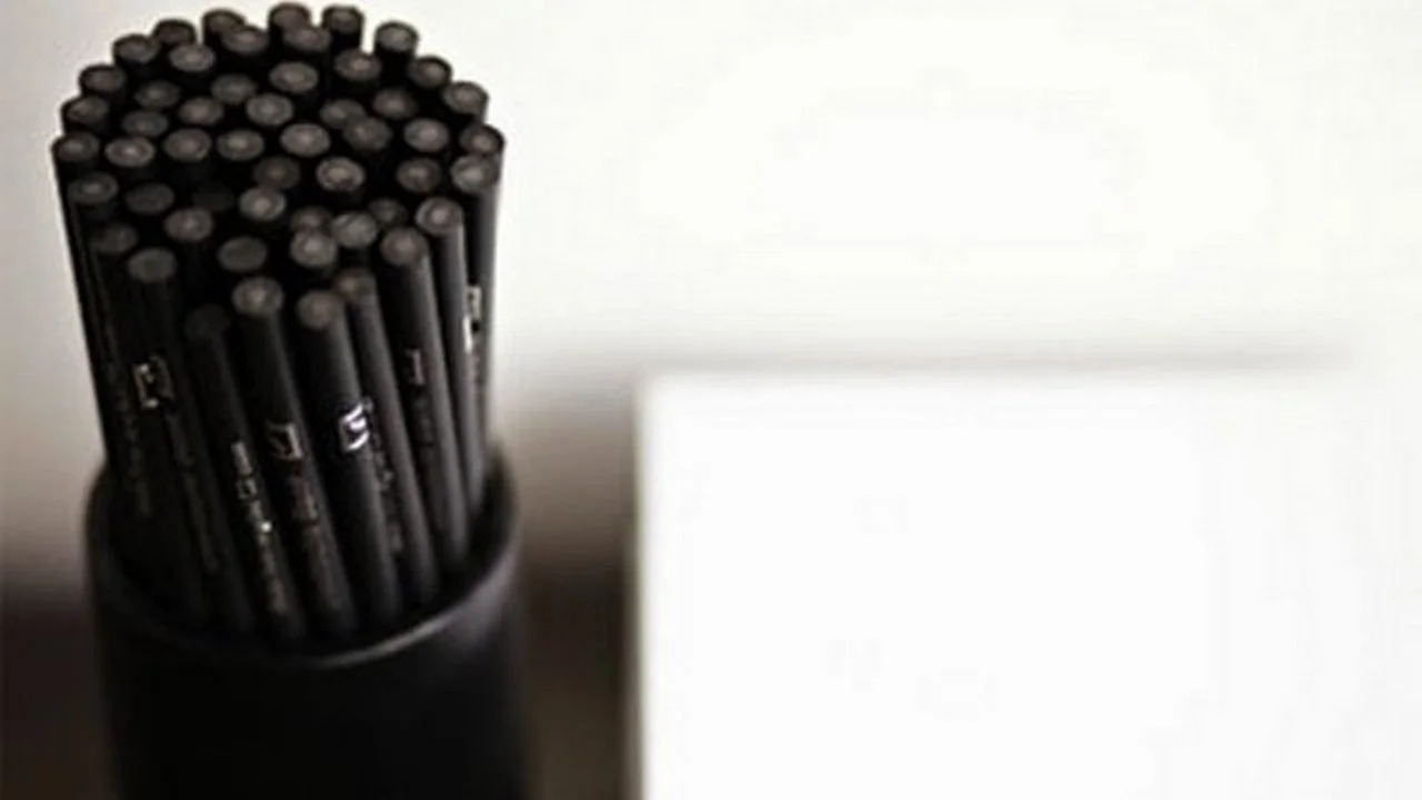 Black pencils made from recycled plastic, standing upright in a pencil holder.