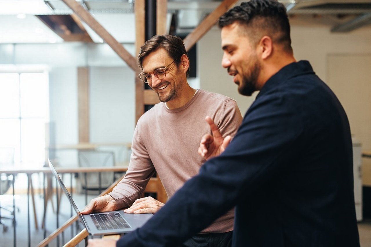 Two men looking at a laptop screen