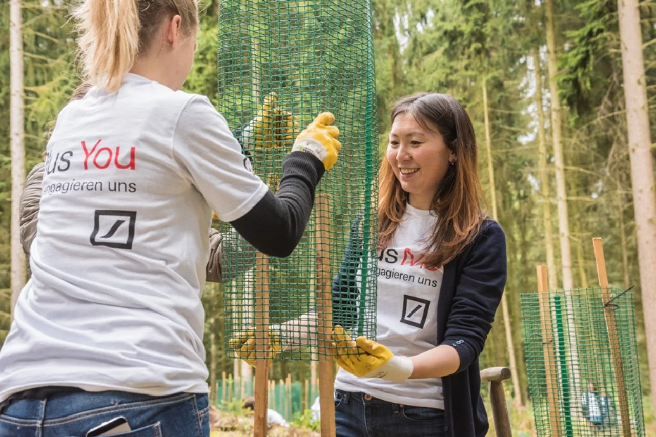 Two volunteers planting a tree in Germany