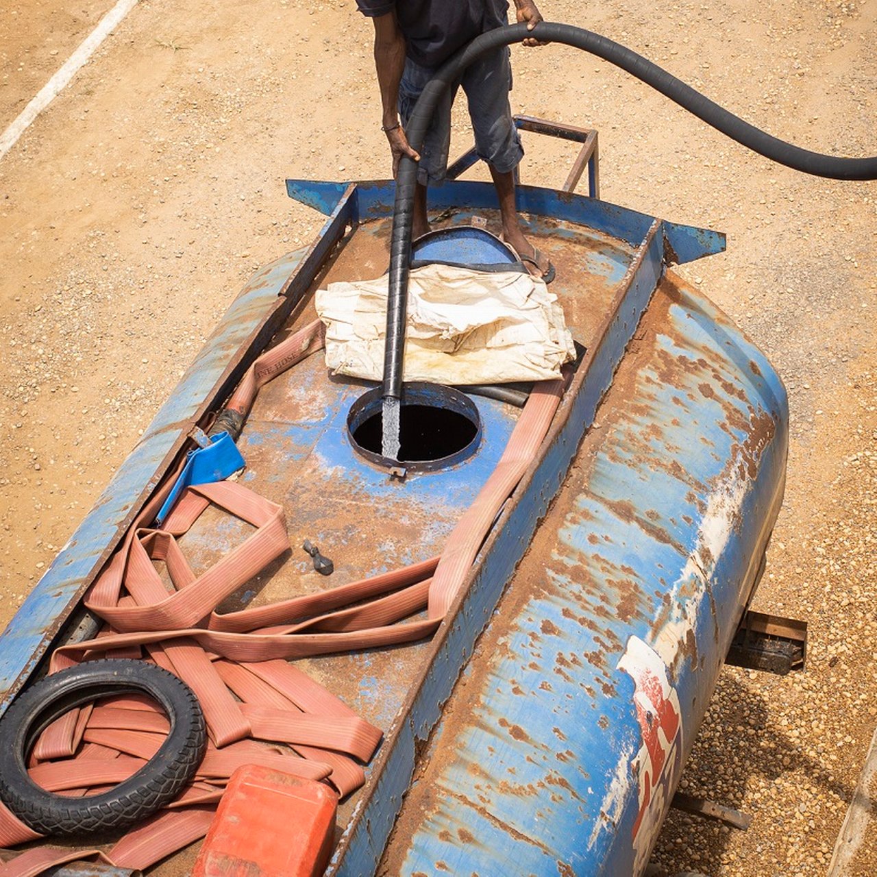 An employee of the Ghana Water Company filling a truck with fresh water