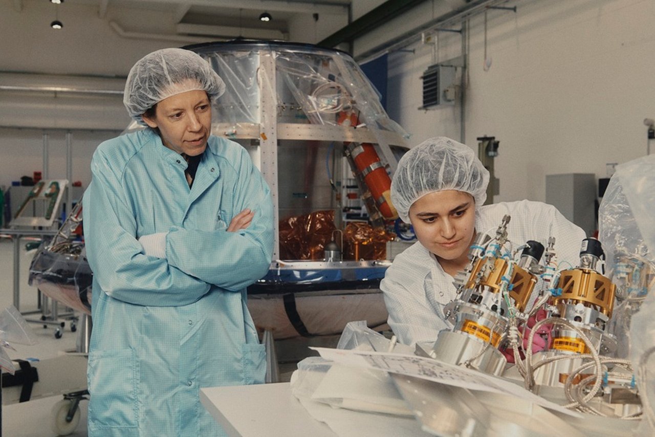 Helene Huby und eine Ingenieurin arbeiten an einem Satellitenbauteil.