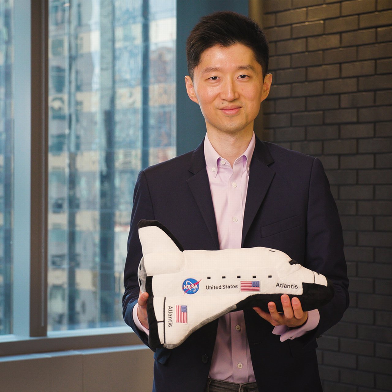 Edison Yu, space expert at Deutsche Bank, holding model of a space shuttle.