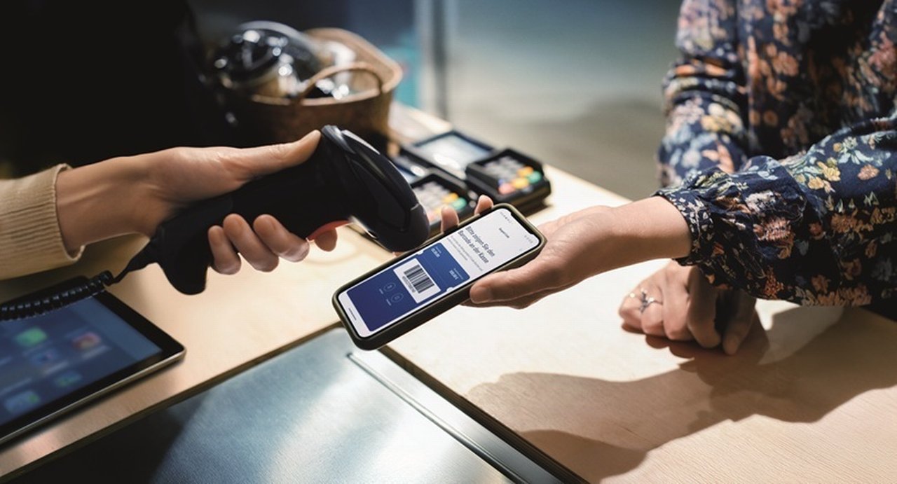 Kunde bezahlt mit Barcode auf dem Handy an der Kasse. Foto © Getty Images und Deutsche Bank.