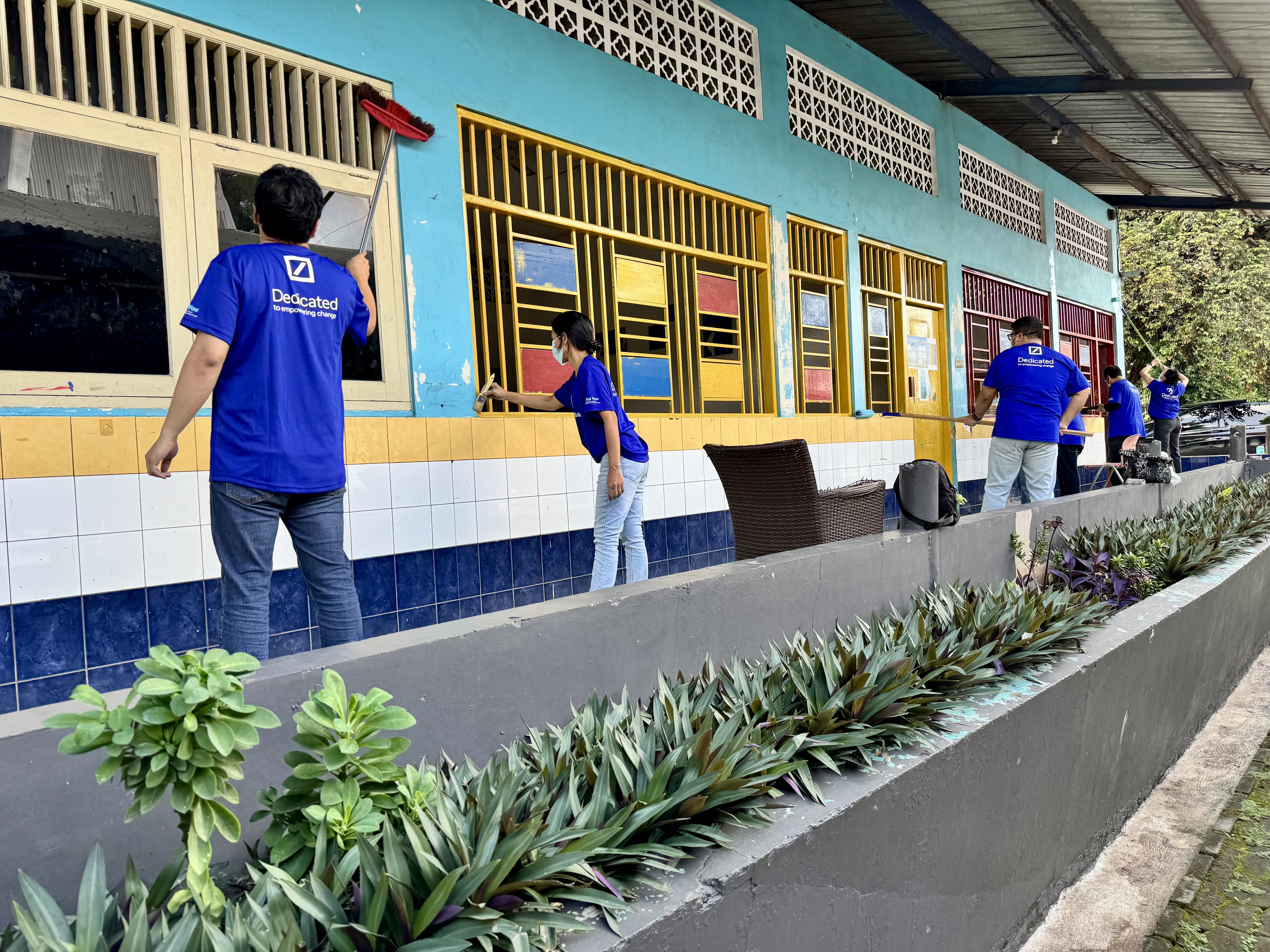 Volunteers painting a school building
