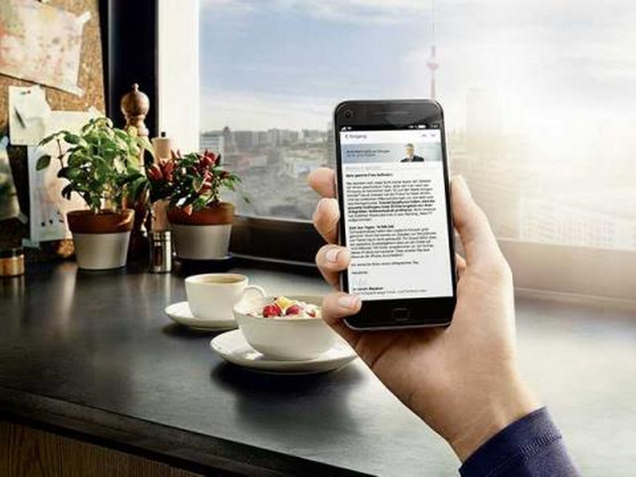 Eine Person liest „PERSPEKTIVEN am Morgen“ mit einem Smartphone während des Frühstücks