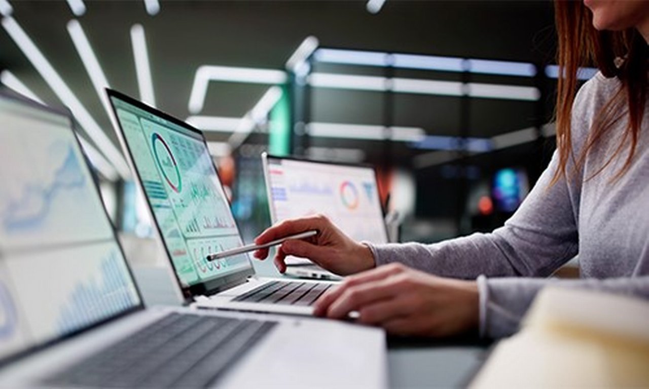 Person pointing to a chart on a laptop.