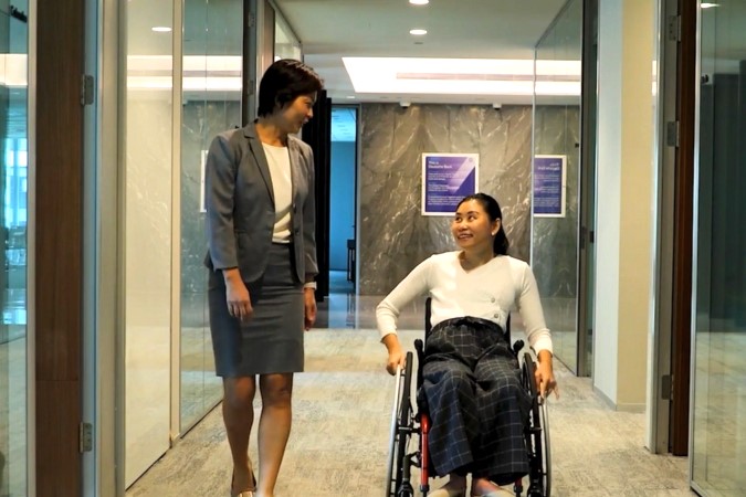 Employee in wheel chair talking to a colleague