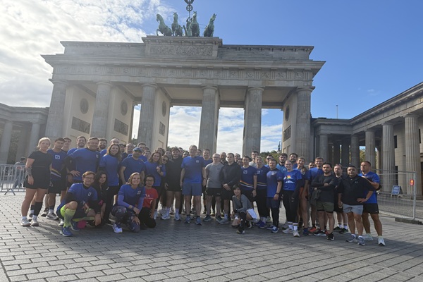 A group of people posing in front of the Brandenburg Gate in Berlin.