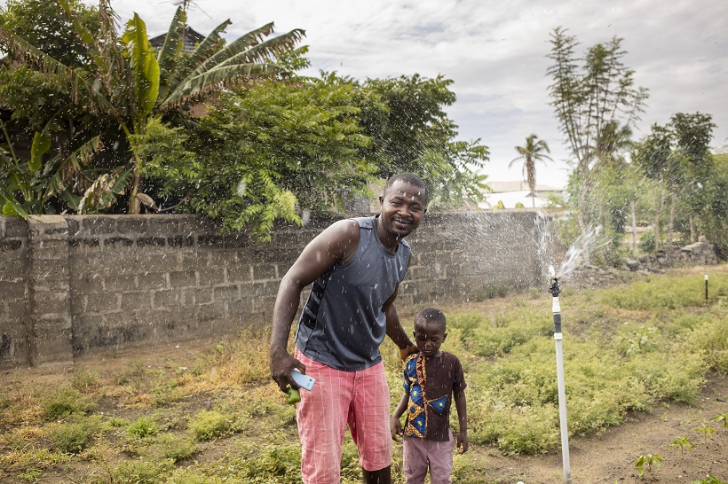Philip Kojo Dawu with his son in the field